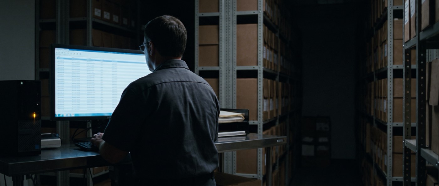 A monitor and phone in a dark room showing a structured record